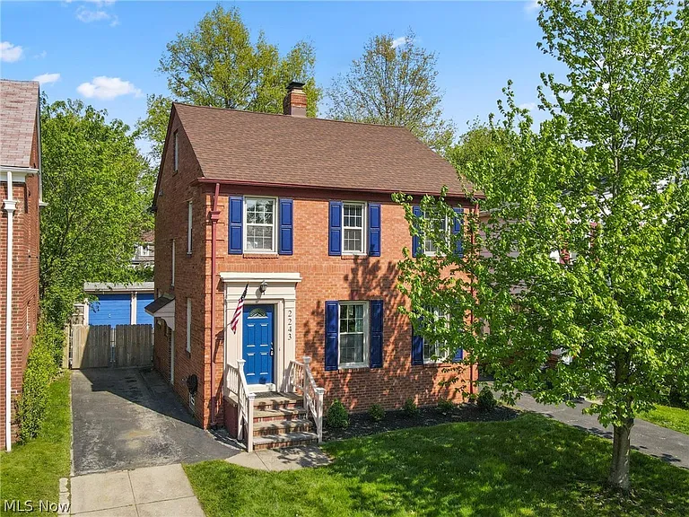 A brick colonial home with blue shutters and an American flag on a tree-lined Cleveland street, the kind of family home a living trust is built to protect.